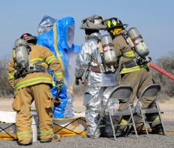 workers wearing level B protection decontaminating worker wearing level A protection