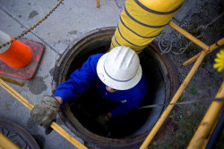 Worker descending into below ground confined space entry