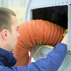 Worker using an air blower to ventilate a confined space