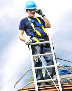man who climbed to the top of a ladder standing on roof making a phone call