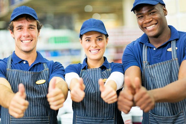 Three workers who just completed training standing side by side with all thumbs up