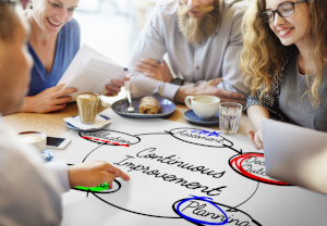 People sitting around table discussing continuous improvement