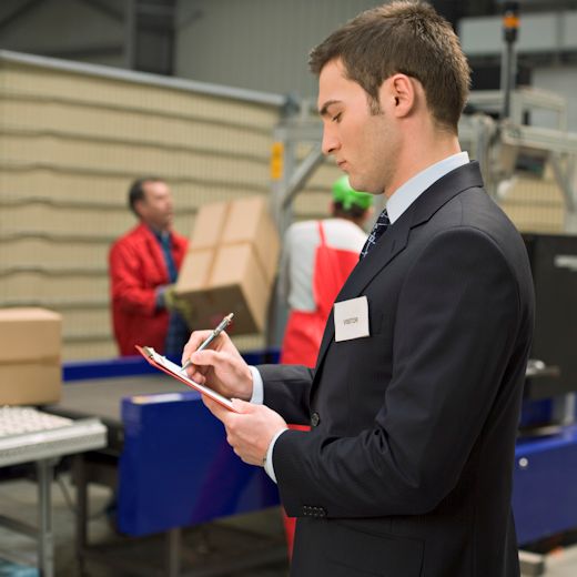Staff overseeing operations inside a building making quality control notations