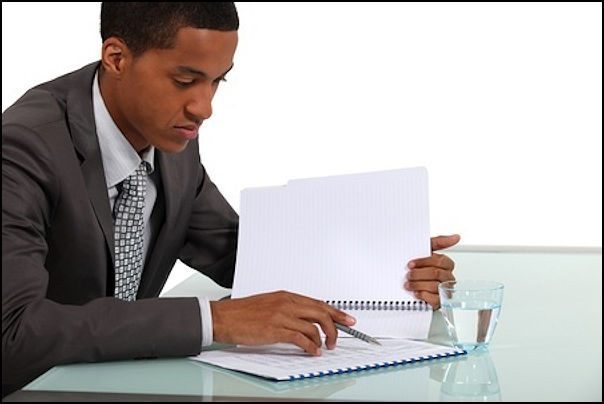 Employee sitting at a table reading the results of a risk analysis
