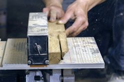 Worker using table saw to cut wood