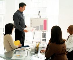 Man leading safety committee meeting showing members a chart