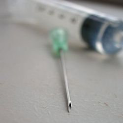 needle and syringe laying on table