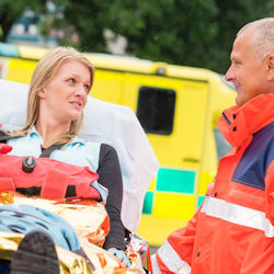 Person being loaded by responder into ambulance