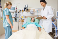 Patient at hospital in bed with a nurse and doctor present