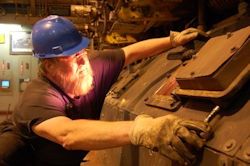 Worker who is wearing PPE is repairing equipment