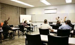Instructor teaching classroom of students about PPE requirements