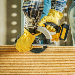 worker wearing gloves while using electric saw
