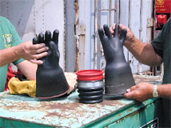 Two workers doing testing on electrical protective gloves
