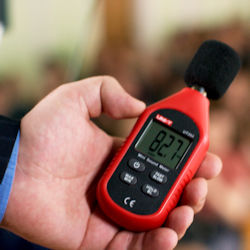 Worker holding a sound level meter