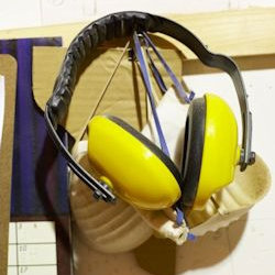 Dust masks and ear muffs hanging together on nail; an OSHA violation.