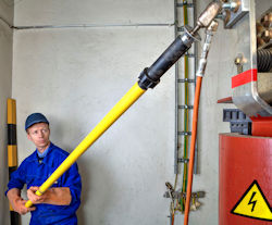 Employee using specially designed tool to reach ceiling lights.