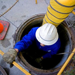 Worker descenting into manhole