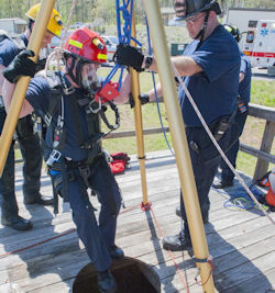 Three workers one is be rescued during a confined space rescue practice. Testing the equipment.