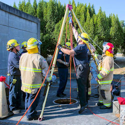 A group of workers outside receiving confined space training
