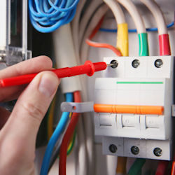 Electrician checking circuit breakers on a distribution panel.