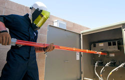 Electrician using protective equipment to perform a switching operation.