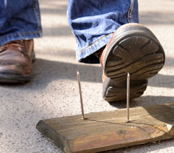 Image of a worker about to step on a nail
