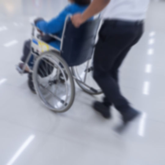 Employee assisting person in wheelchair to Alternate Evacuation Route