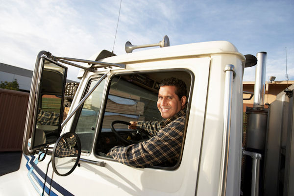 Truck driver sitting in cab of large truck.