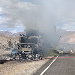 Smashed crashed smoking big rig accident on desolate roadway.