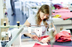 an employee sitting and working at a sewing machine