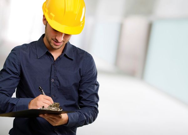 Employee doing a walk around inspection and taking notes.
