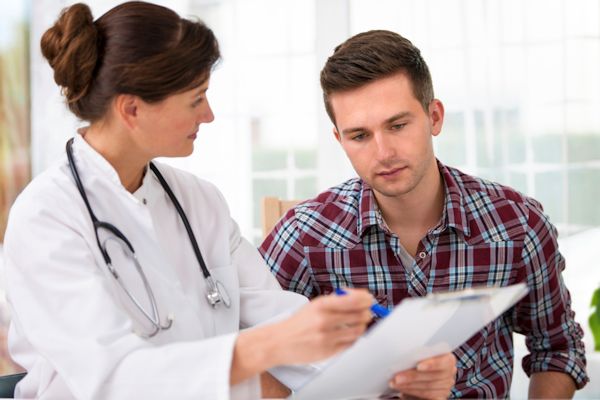 Image showing doctor reviewing medical records with an patient.