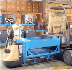 worker charging batteries on an electric forklift