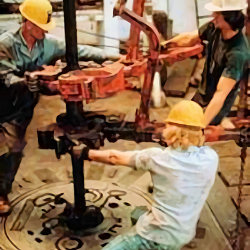 Image of three workers performing well drilling operations.