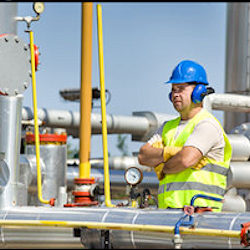 Image of employee monitoring pressure in pipes.