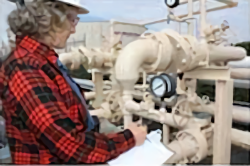 Image of woman checking meters.