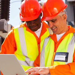 Image of two workers using computer to audit PSM Process Safety Management records.