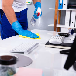 Gloved worker cleaning a work area