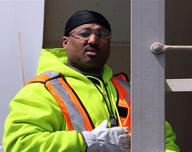 a worker holding open a entry door.