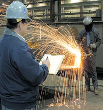 inspector conducting a walk-around inspection around the welding area.