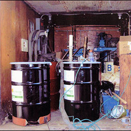 Two black sealed drums possibly with toxic chemicals.