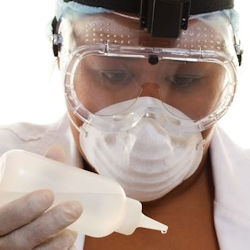 Lab worker with PPE testing food for biological agents.