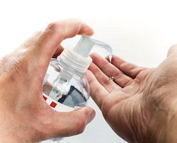 person using dispenser to apply hand gel