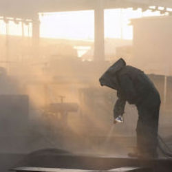 Worker in full PPE surrounded by dust, gases and particulates all respiratory hazards