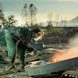 Worker in full PPE working outside around hazardous respiratory conditions