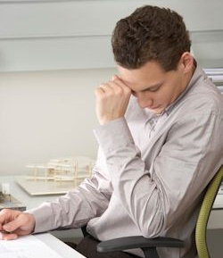 Image of worker feeling stress sitting at desk.