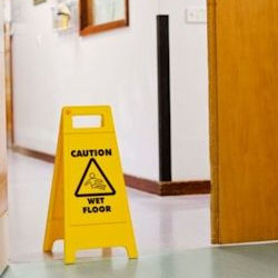 Image of slippery floor with sign showing Caution wet floor.