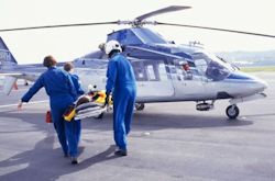 Image of workers loading patient into helicopter with dangerous rotating blades.