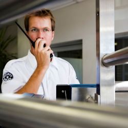 Image of security worker speaking on two-way radio.