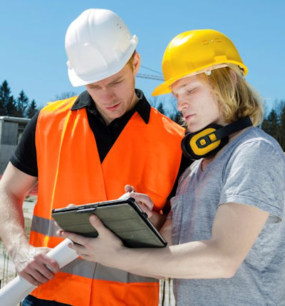 Image of two employees outside checking information on a clipboard